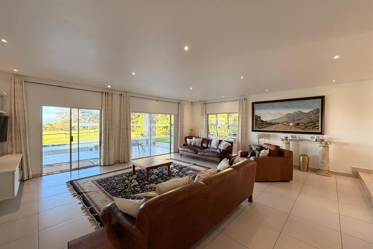 Spacious living room featuring large sliding glass doors that provide abundant natural light and direct access to the outdoor patio and pool area.