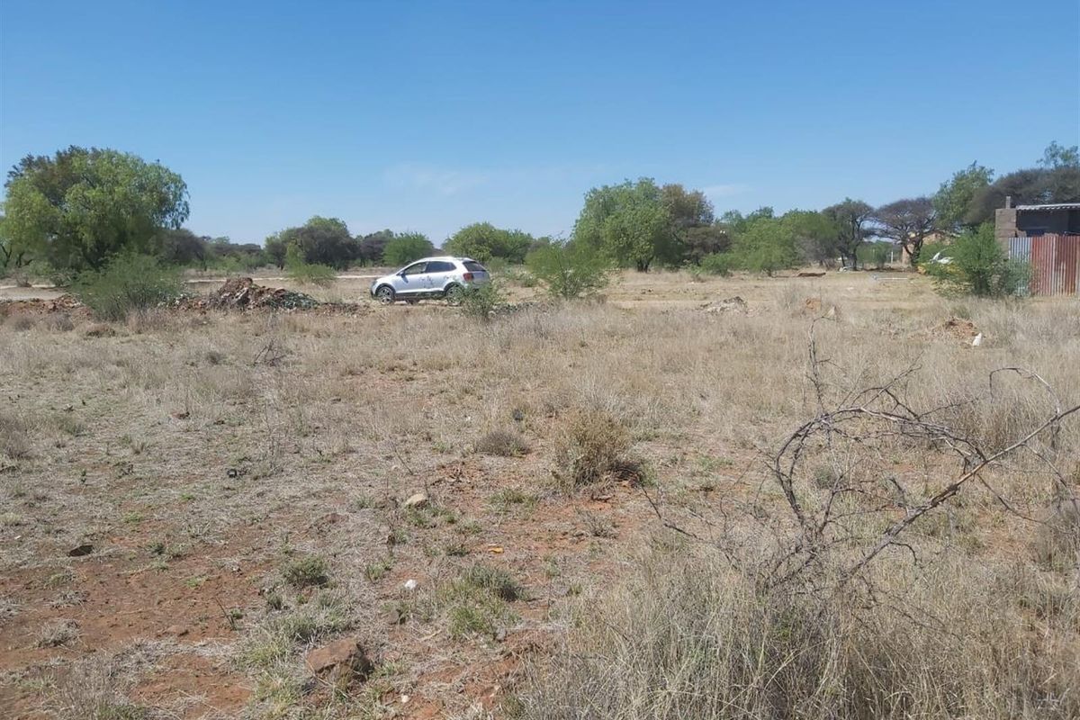 A view of a vacant residential plot featuring natural vegetation and open space, suitable for future development.