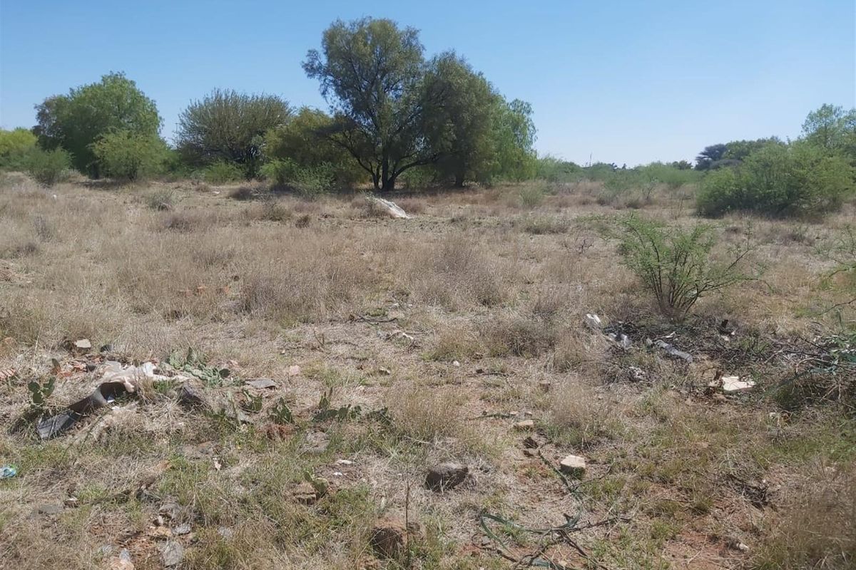 A view of a vacant residential plot featuring native vegetation and open land, suitable for future development.