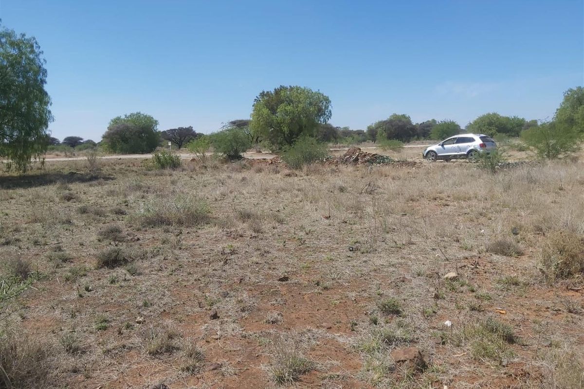 A view of a vacant residential plot featuring natural vegetation and open space, suitable for future development.
