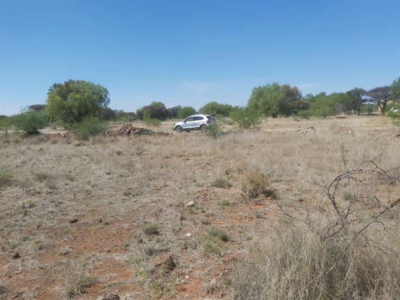 A view of a vacant residential plot featuring natural vegetation and open land, suitable for future development.