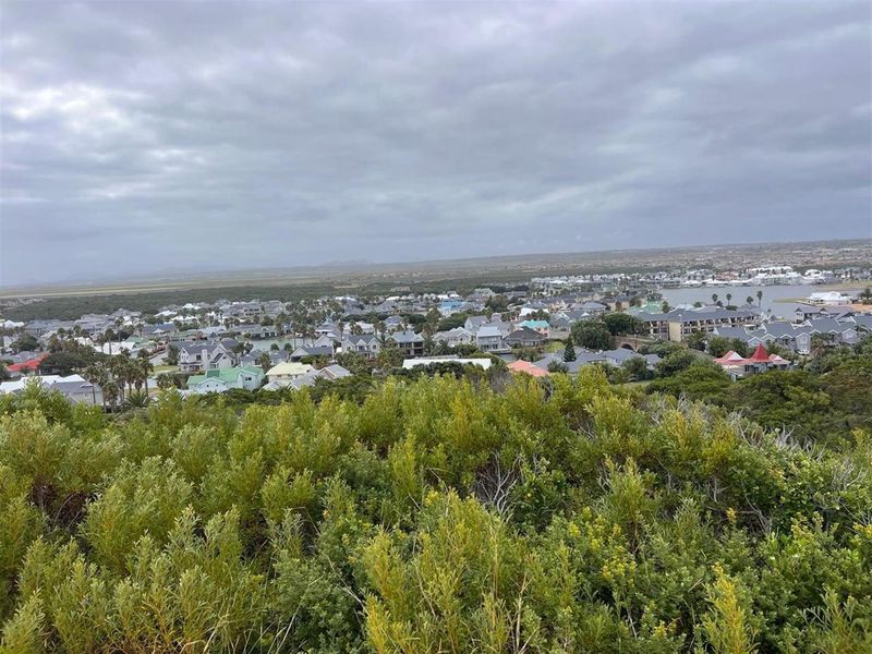 An elevated view overlooking a residential coastal estate and surrounding landscape, showcasing the property's scenic location and neighborhood context.