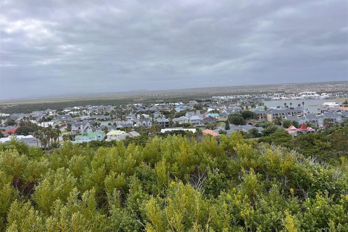 An elevated view overlooking a residential coastal estate and surrounding landscape, showcasing the property's scenic location and neighborhood context.