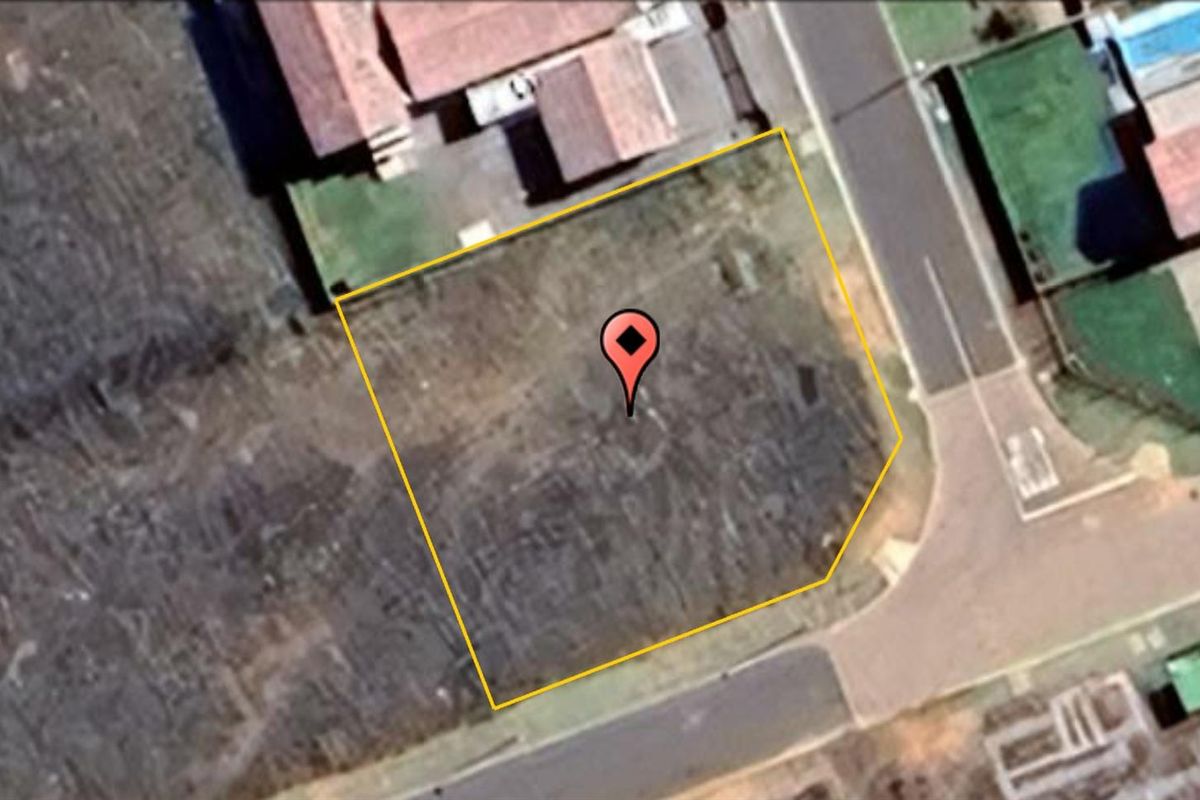 An aerial view of a vacant residential plot, highlighting the property boundaries and its location within the established neighborhood street layout.