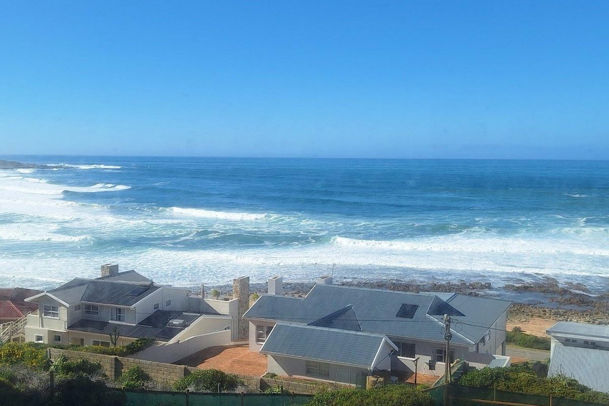 Elevated aerial view overlooking coastal residential properties with direct ocean and beach frontage.