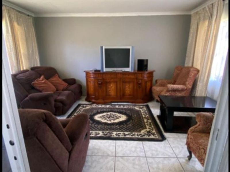 A living room featuring tiled flooring and neutral wall finishes, providing a functional space for relaxation.