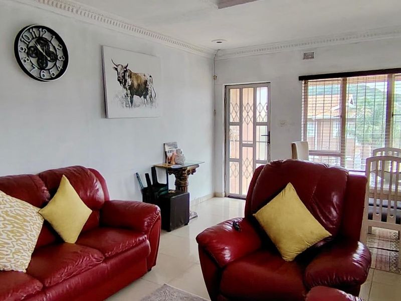 Open plan living and dining area featuring tiled flooring, decorative cornicing, and large windows providing natural light.