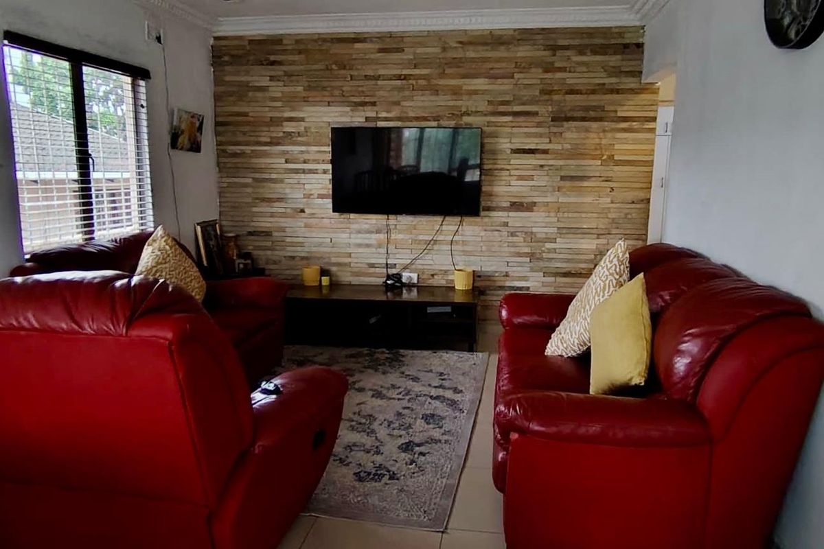 A cozy living room featuring a textured wood-cladding feature wall and tiled flooring, providing a warm and inviting atmosphere.
