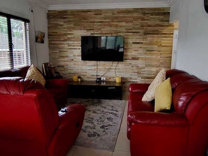 A cozy living room featuring a textured wood-cladding feature wall and tiled flooring, providing a warm and inviting atmosphere.