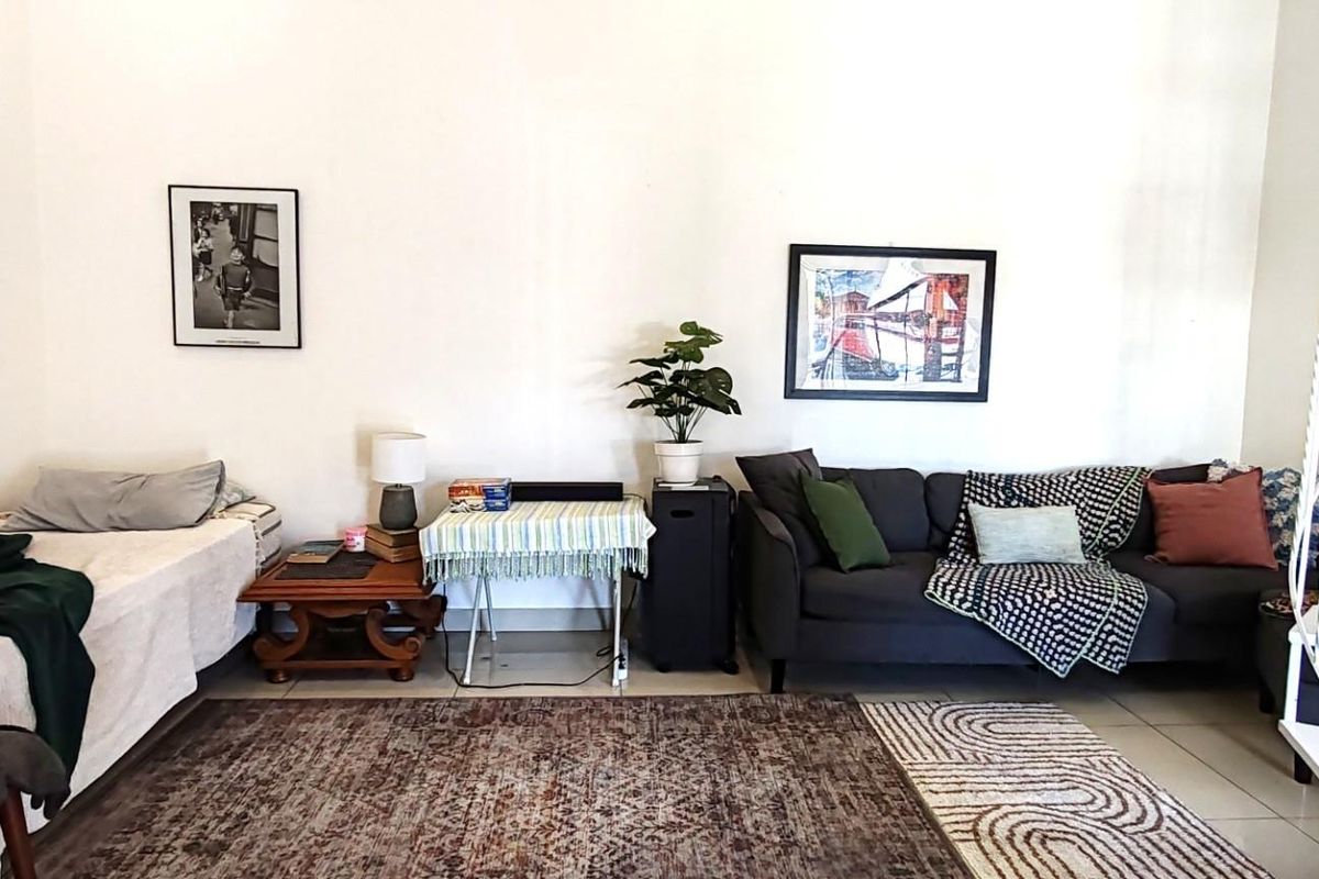 A spacious living area featuring tiled flooring and a white spiral staircase leading to an upper level.