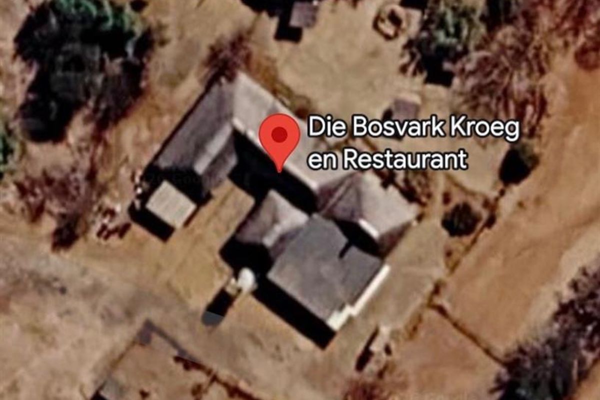 An aerial view of the property showing the main building structure and surrounding grounds on the small holding.