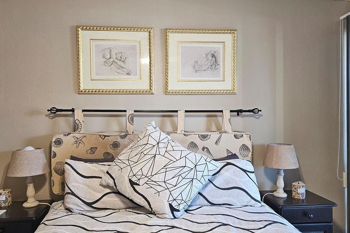 A bedroom featuring neutral wall tones and a sliding glass door providing natural light access.
