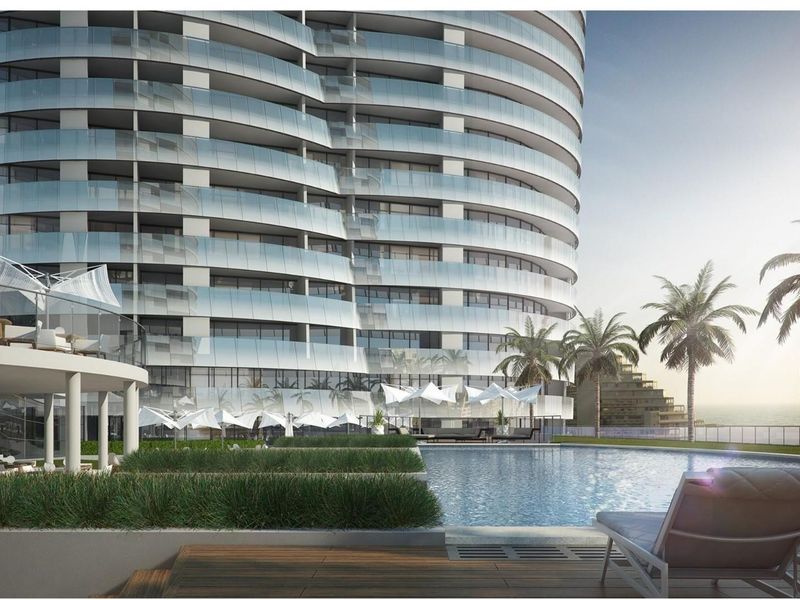 A modern high-rise apartment building featuring a swimming pool area with landscaped garden beds and a contemporary architectural design.
