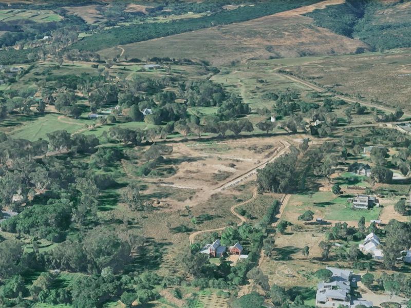 An aerial view of the residential vacant land, showcasing the surrounding landscape, natural vegetation, and established neighborhood context.