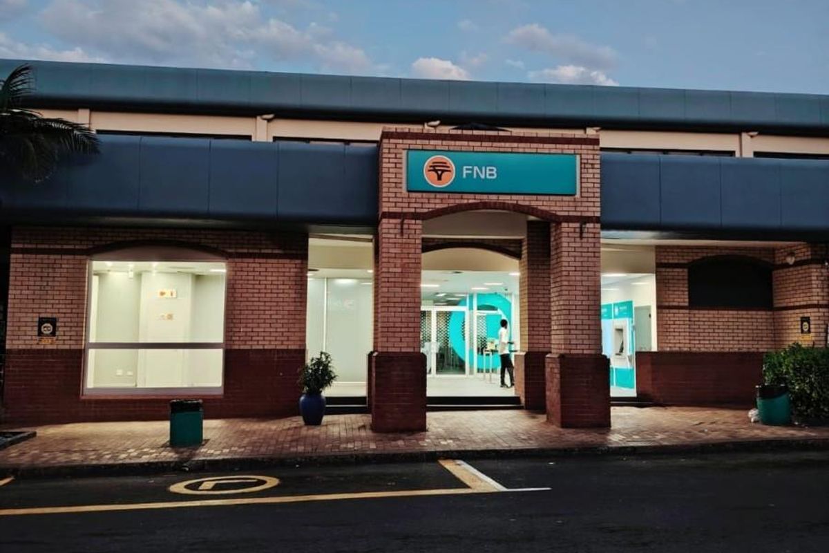 Front exterior view of a commercial bank branch featuring brick facade, large glass windows, and a prominent entrance.