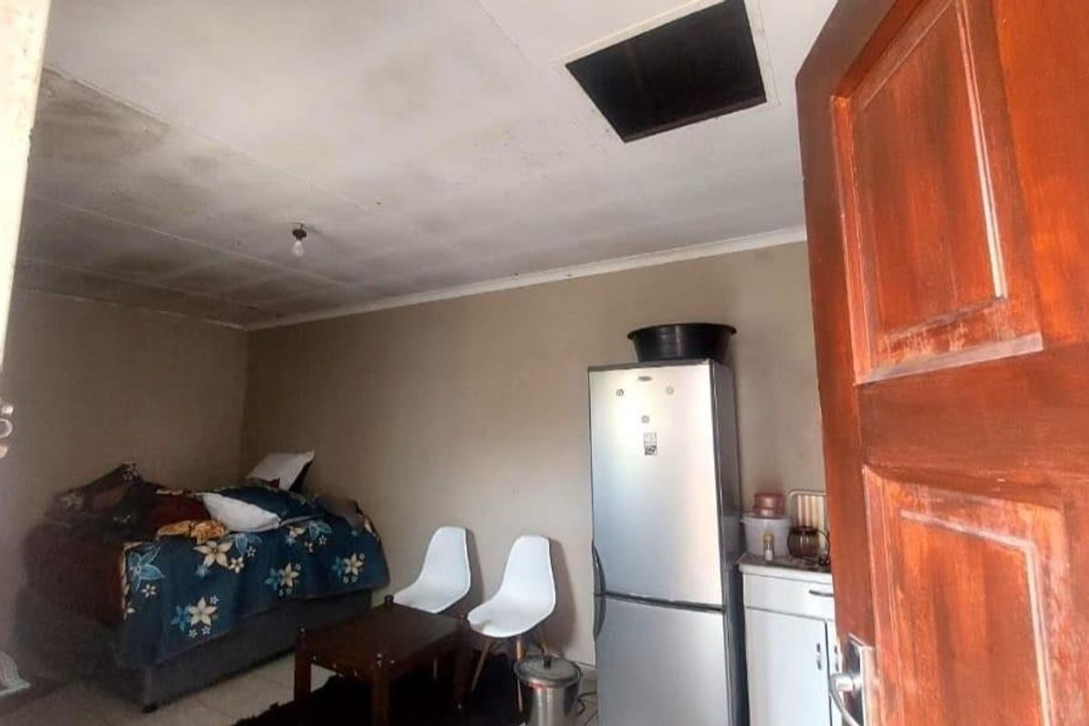 A bedroom space featuring a ceiling access hatch, basic finishes, and a compact layout suitable for renovation.