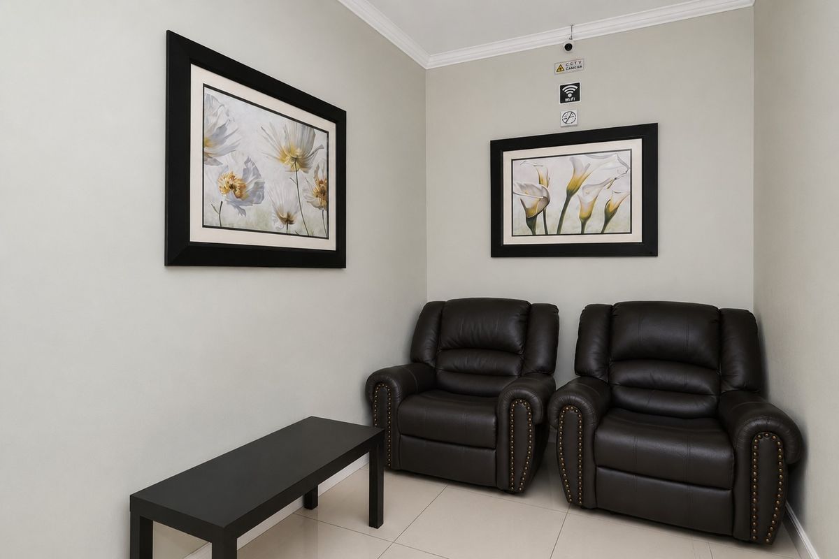 A small waiting area featuring tiled flooring, neutral wall finishes, and integrated security camera infrastructure.