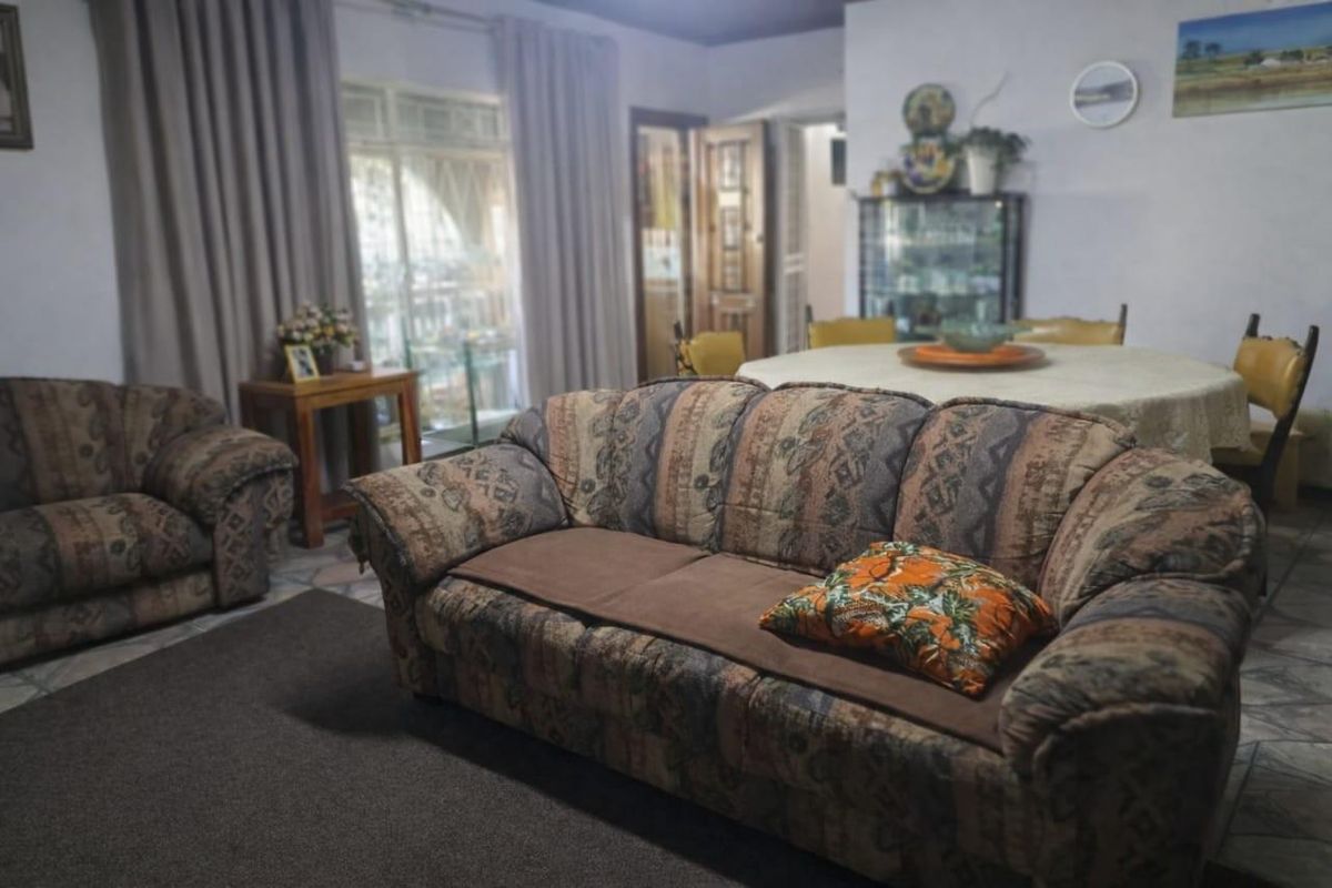A living room area featuring tiled flooring and a sliding glass door leading to an outdoor space.