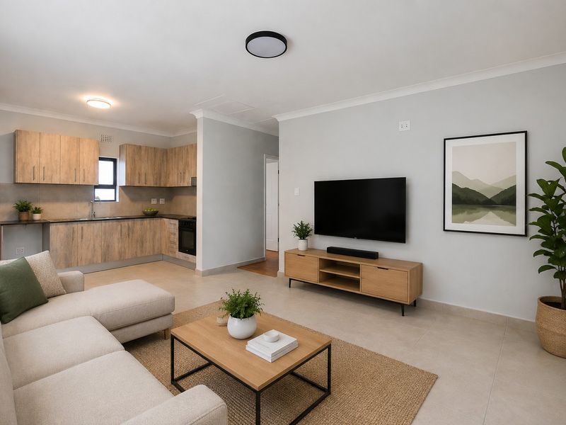An open-plan living area featuring a modern kitchen with wood-finish cabinetry, tiled flooring, and a spacious lounge area with neutral finishes.
