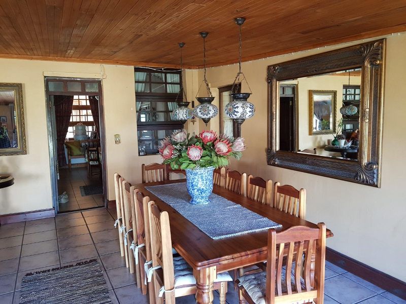 A rustic dining room featuring a timber-clad ceiling, tiled flooring, and decorative pendant lighting, creating a warm and traditional atmosphere.