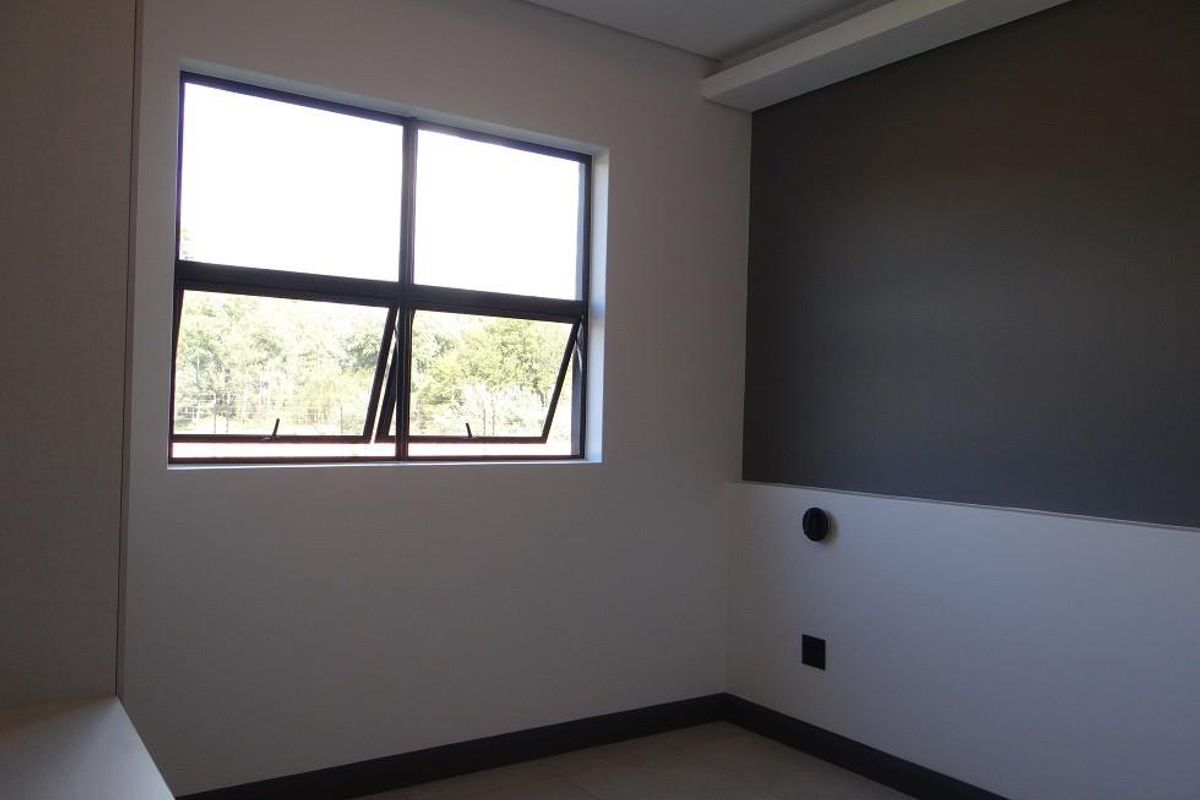 A bright, modern bedroom featuring neutral tones, tiled flooring, and a large window providing natural light.