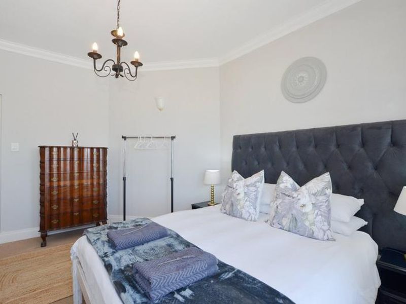 A well-maintained bedroom featuring crown molding, a ceiling rose, and neutral wall finishes, providing a clean and comfortable living space.
