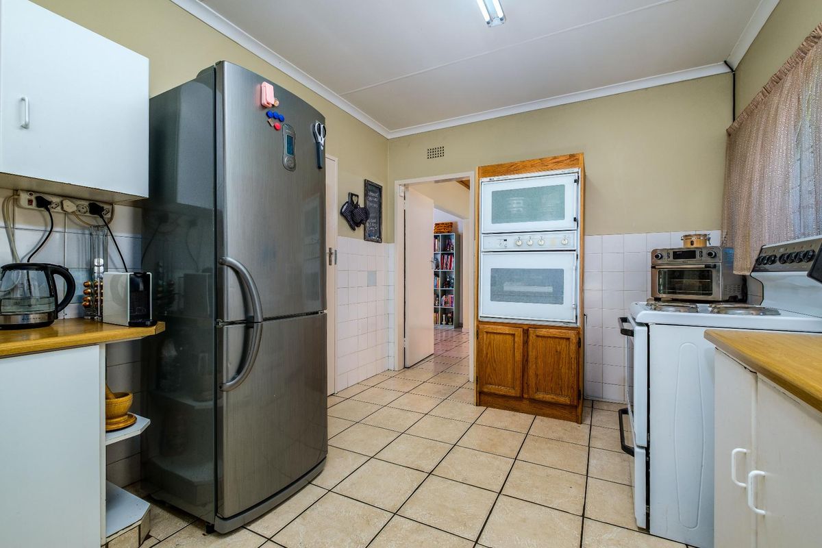 A functional kitchen featuring tiled flooring, built-in wall oven, and tiled splashbacks, providing a practical layout for daily meal preparation.