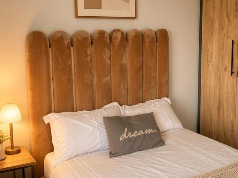 A well-maintained bedroom featuring neutral tones, built-in wooden wardrobe cabinetry, and modern laminate flooring.
