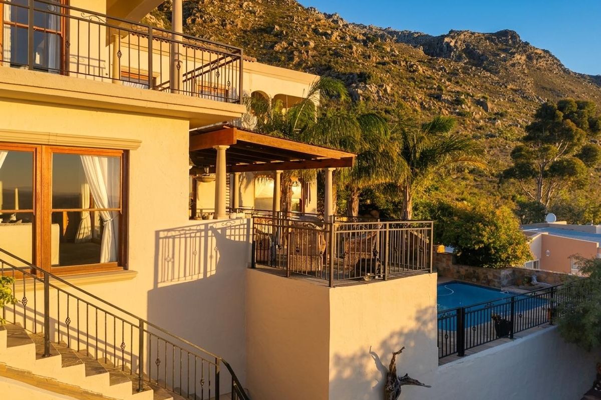 A multi-level exterior view featuring a spacious patio, swimming pool, and balcony, set against a scenic mountain backdrop.