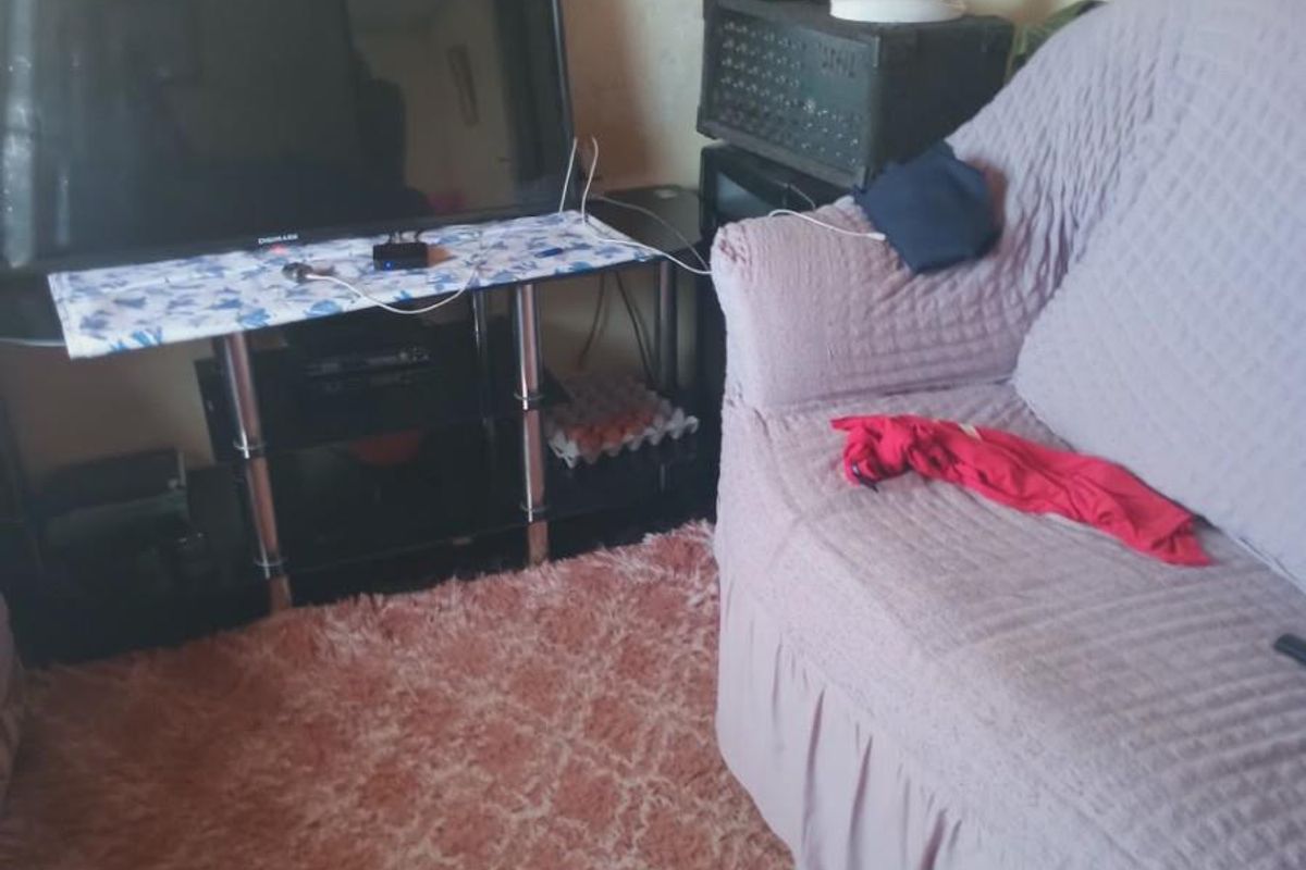 A living room area showing signs of significant wear and tear on the walls, requiring maintenance and cosmetic updates.