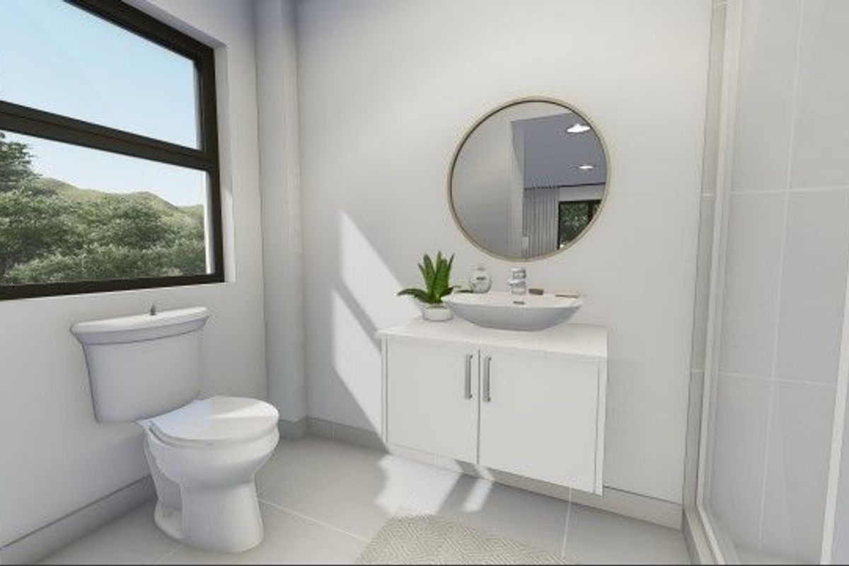 A modern, bright bathroom featuring a wall-mounted vanity with a vessel sink, a round mirror, and a standard toilet.