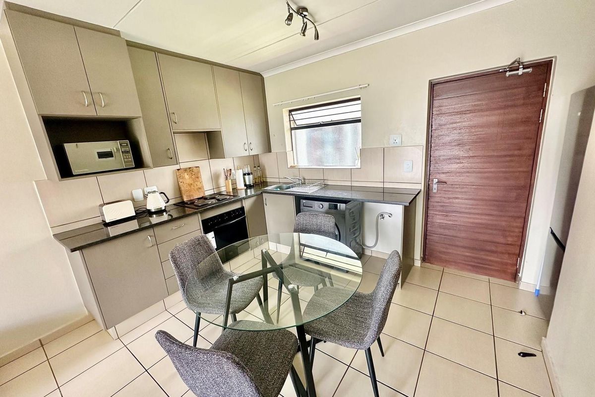 A functional kitchen featuring built-in cabinetry, granite countertops, integrated appliances, and tiled flooring, providing a practical and well-maintained cooking space.