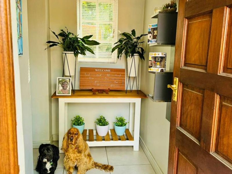 A welcoming entrance hall featuring tiled flooring, a timber front door, and a window with venetian blinds.