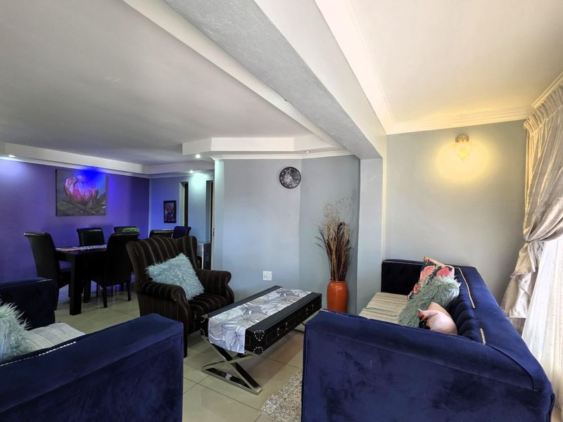 Spacious open-plan living and dining area featuring tiled flooring, coved cornicing, and recessed ceiling lighting, creating a versatile and well-defined multi-purpose space.