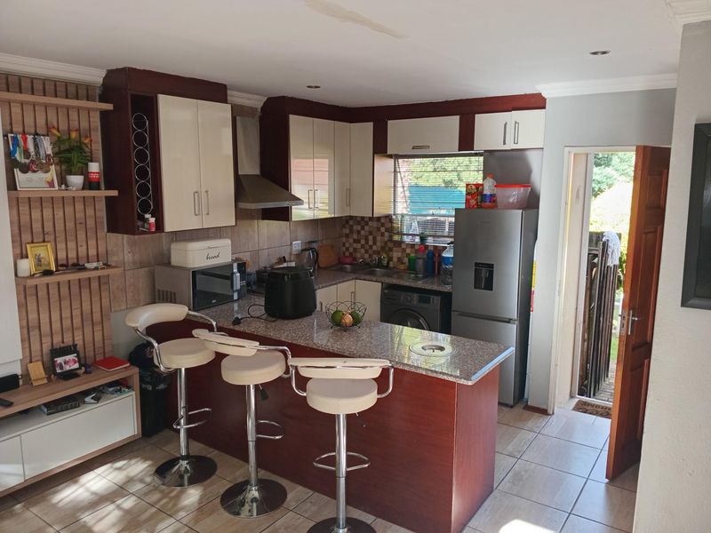 A functional kitchen featuring granite countertops, a breakfast bar, built-in cabinetry, and direct access to the exterior.