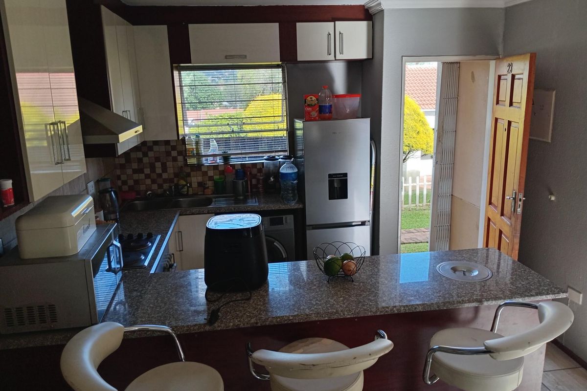 Compact kitchen featuring granite countertops, a breakfast bar, built-in cabinetry, and direct access to the exterior.