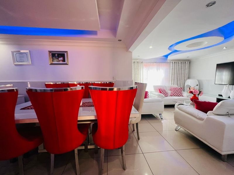 Spacious open-plan living and dining area featuring modern recessed ceiling lighting, tiled flooring, and a contemporary layout suitable for entertaining.