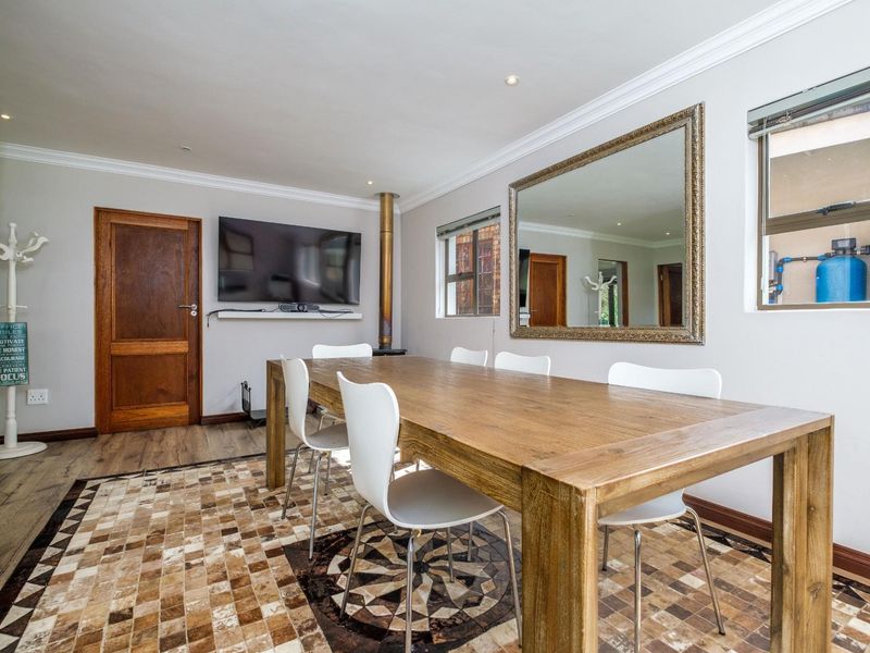 A dining room featuring a wood-burning fireplace, tiled flooring with a decorative inlay, and crown molding.