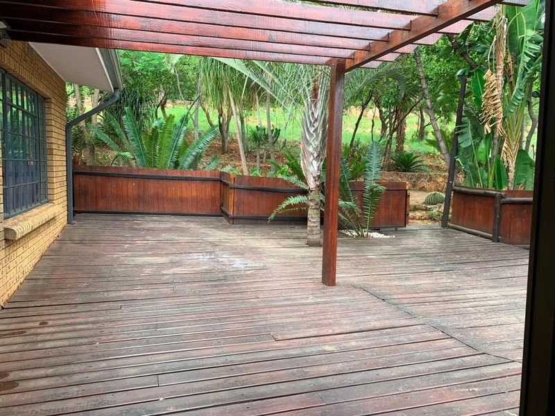 A spacious outdoor timber deck featuring a wooden pergola, providing a functional area for outdoor living and entertaining.