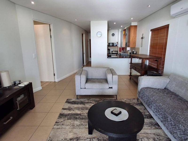 Open plan living area featuring tiled flooring, recessed ceiling lighting, and a split-system air conditioning unit, seamlessly connecting to the kitchen space.