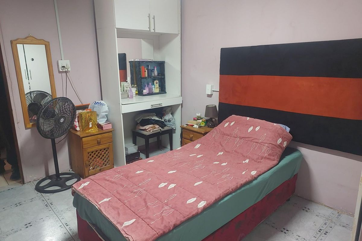 A bedroom featuring tiled flooring and a built-in vanity unit, requiring cosmetic updates to improve the overall aesthetic and condition.