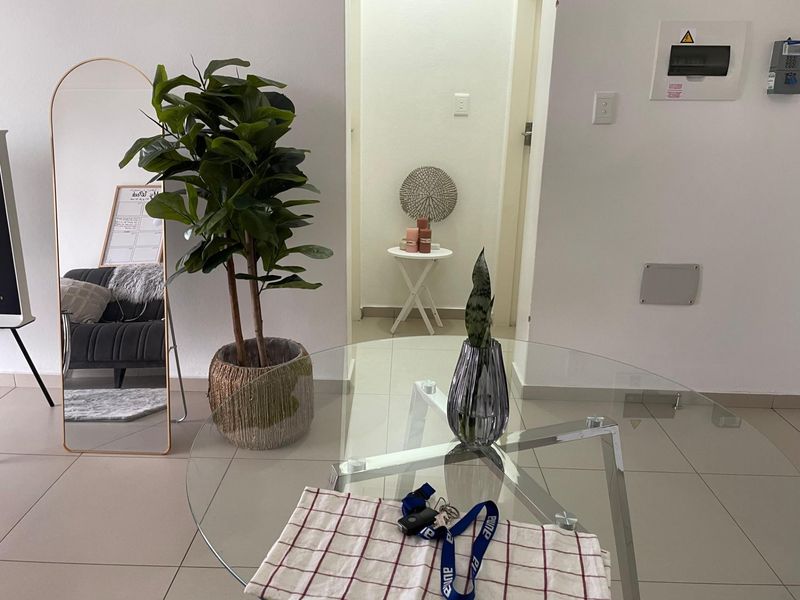 A view of an interior hallway and living space featuring tiled flooring and a built-in electrical distribution board.