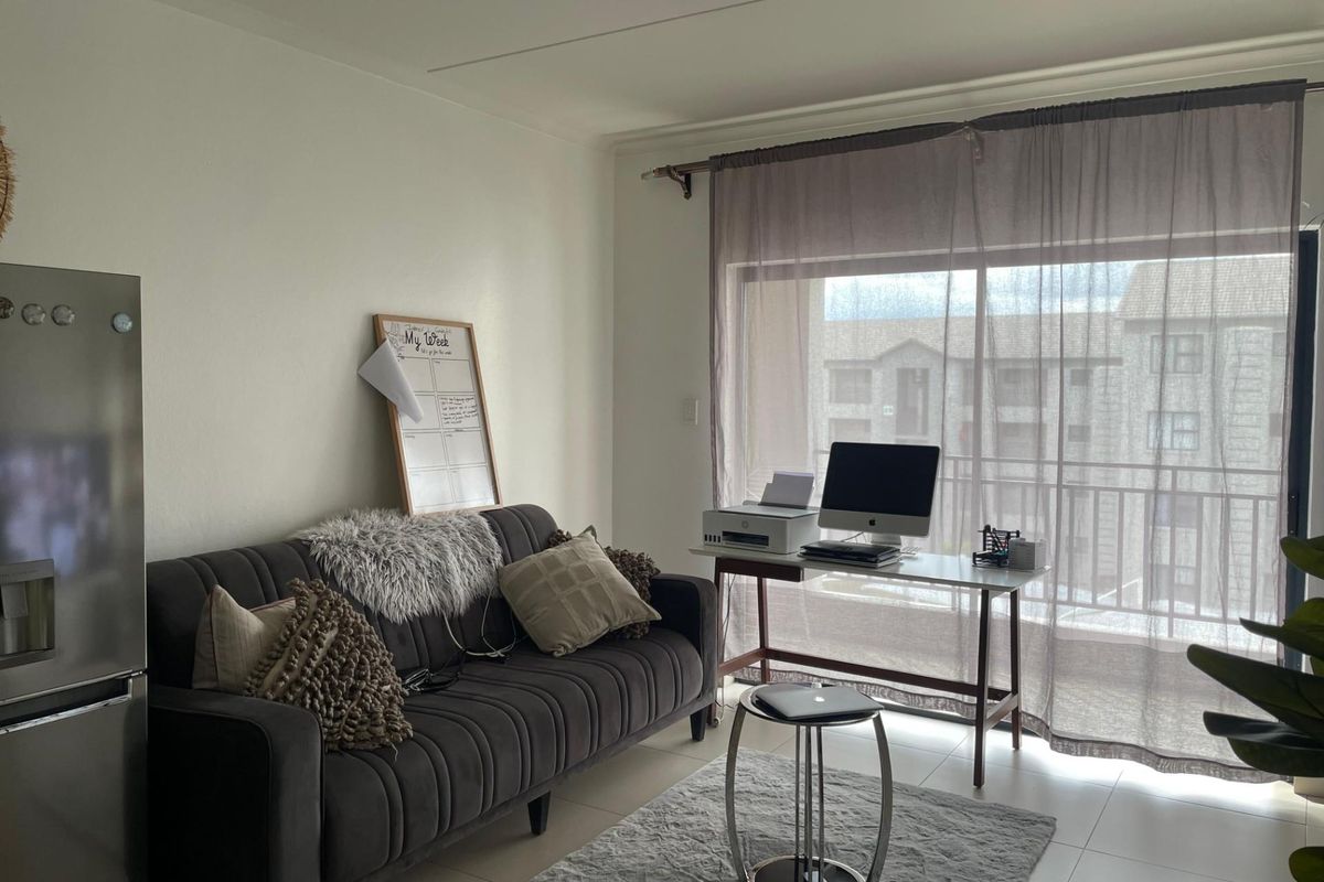 A functional living area featuring tiled flooring and large sliding glass doors that provide access to a balcony.