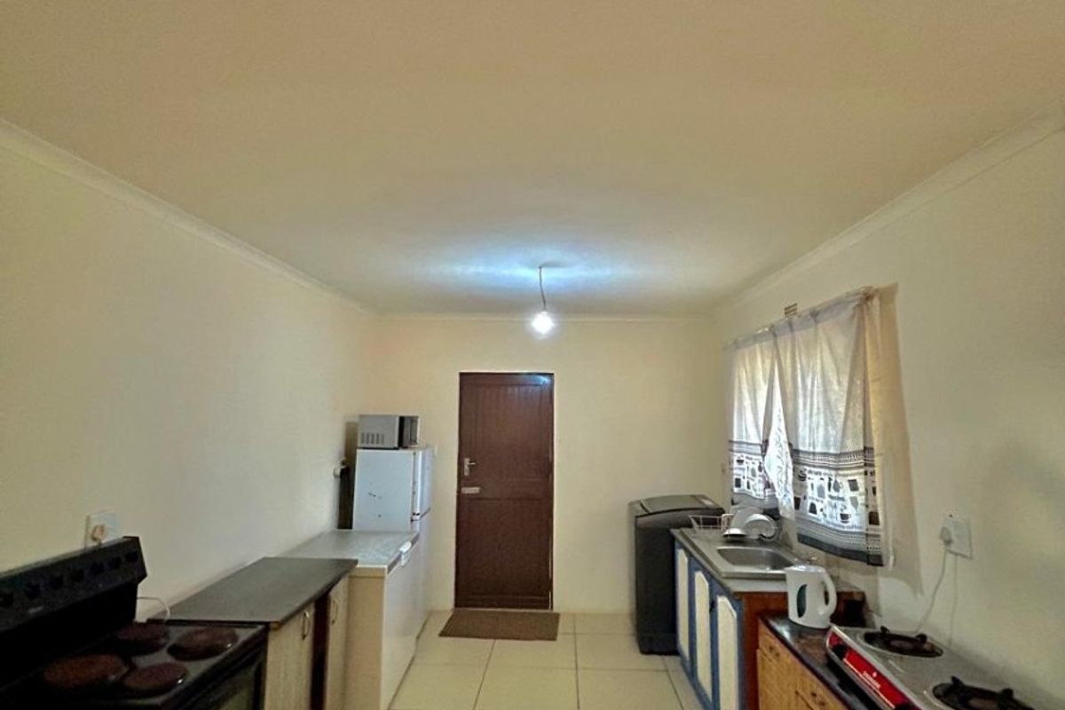 A functional kitchen featuring tiled flooring, built-in cabinetry, and a stove, providing a practical workspace for daily meal preparation.