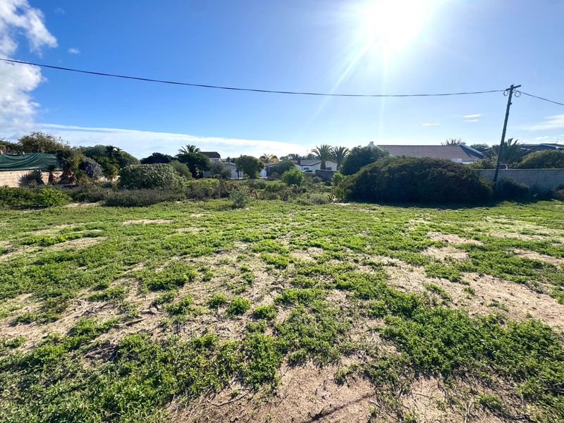 A vacant residential plot featuring natural vegetation and sandy terrain, offering a clear space for future development.