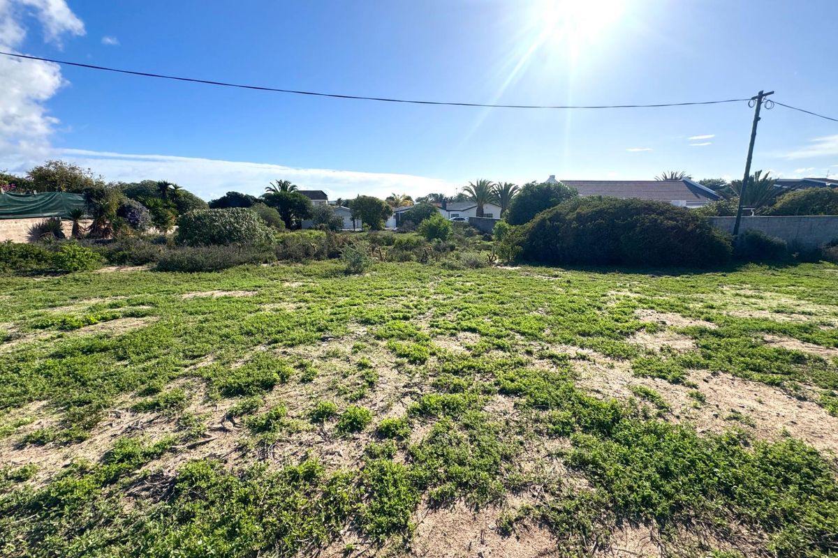 A vacant residential plot featuring natural vegetation and sandy terrain, offering a clear space for future development.