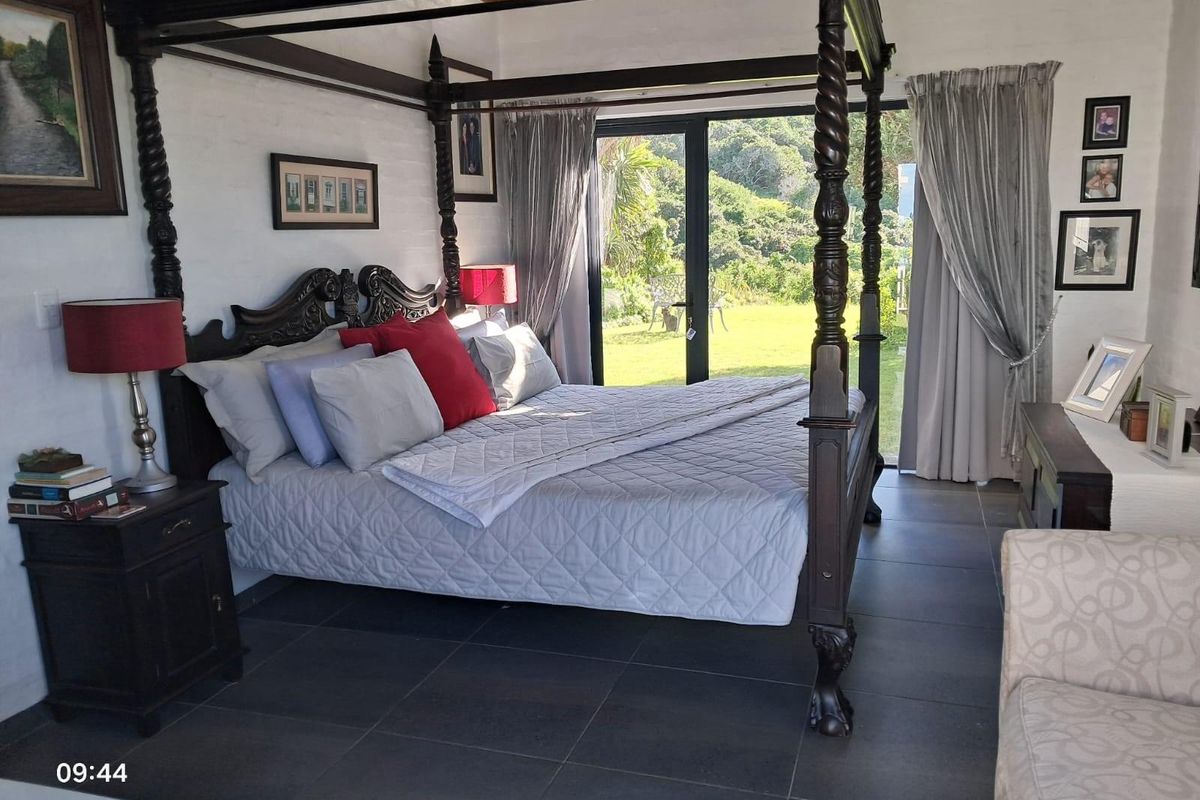 Spacious bedroom featuring dark tiled flooring, exposed white brick walls, and large glass sliding doors providing direct access to the garden.