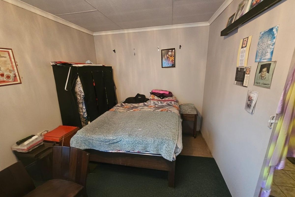 A compact bedroom featuring neutral wall finishes, a tiled ceiling, and carpeted flooring.