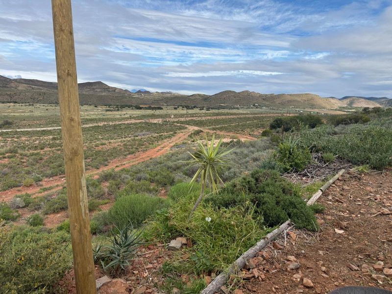 Expansive landscape view overlooking the farm property, featuring rolling hills and natural vegetation.