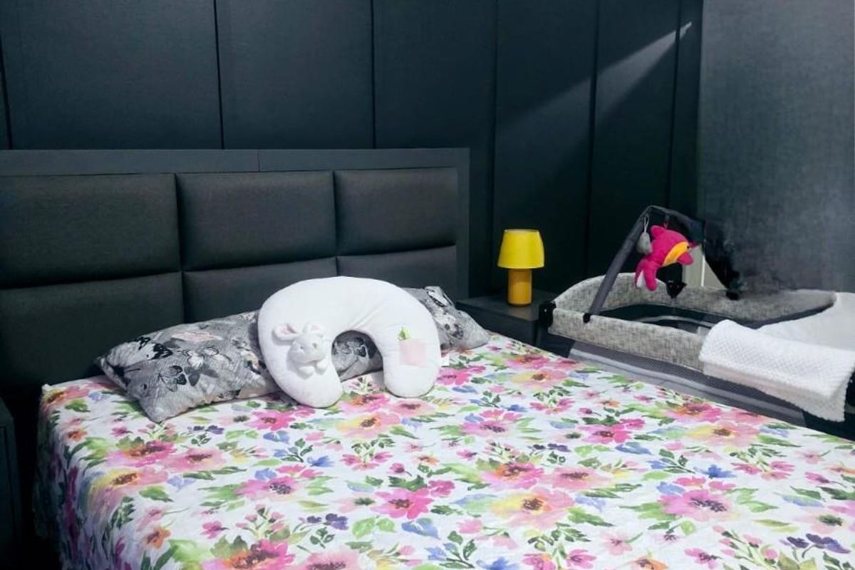 A bedroom featuring a dark feature wall with integrated paneling and a wall-mounted air conditioning unit.